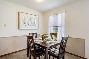 Grandville apartment for rent - A dining room with a table set for two and a painting on the wall.
