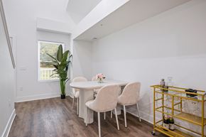 Kalamazoo apartment for rent - A dining room with a white table and chairs and a yellow cart.