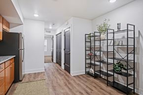 Kalamazoo apartment for rent - A kitchen with a black refrigerator and wooden floors.
