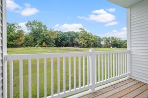 Kalamazoo apartment for rent - A white deck with a white railing overlooking a grassy field.