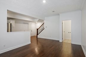 Caledonia apartment for rent - A spacious room with a wooden floor and a staircase.