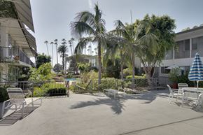 Santa Monica apartment for rent - a patio with tables and chairs and palm trees