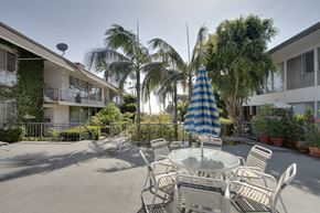 Santa Monica apartment for rent - a patio with tables and chairs and a blue and white umbrella