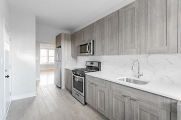 Chicago apartment for rent - a kitchen with wooden cabinets and a sink and a stove