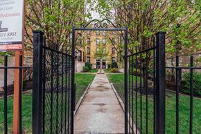 Chicago apartment for rent - an open gate leading to a sidewalk in front of a building