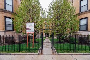 Chicago apartment for rent - the entrance to a building with a yard behind a gate