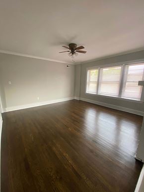 Chicago apartment for rent - an empty living room with a ceiling fan and wood floors