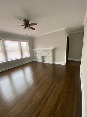 Chicago apartment for rent - an empty living room with wooden floors and a ceiling fan