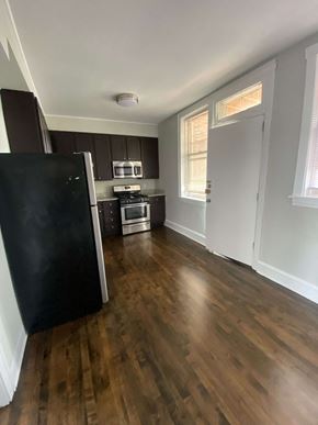 Chicago apartment for rent - an empty kitchen with wooden floors and a refrigerator