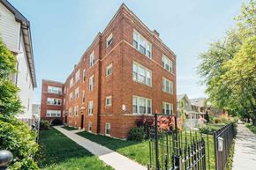 Chicago apartment for rent - a red brick building with a sidewalk in front of it