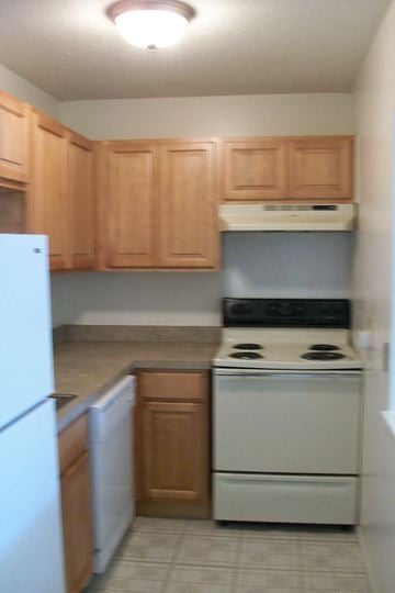 Gretna apartment for rent - a kitchen with white appliances and wooden cabinets
