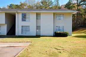 Tuscaloosa apartment for rent - A white apartment building with a green lawn in front.