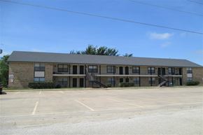 Aubrey apartment for rent - an apartment building with an empty parking lot