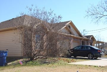 Aubrey triplex for rent - A house with a car parked in front.