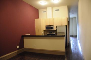 Denton apartment for rent - a kitchen with white cabinets and a black counter top