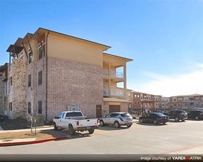 Denton apartment for rent - A white pickup truck is parked in front of a two-story apartment building.