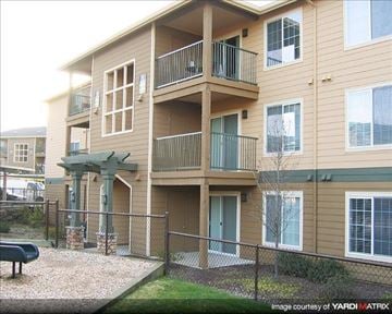 Gresham apartment for rent - A building with a balcony and a small tree in front.