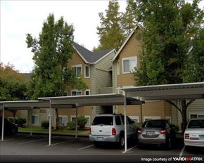 Clackamas apartment for rent - A carport with three cars parked in front of a two-story house.