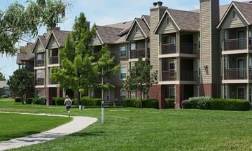 Wichita apartment for rent - a person walking down a sidewalk in front of an apartment building