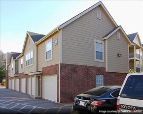 Edmond apartment for rent - a row of houses with cars parked in a parking lot