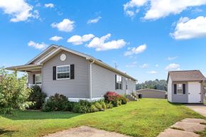 New Providence apartment for rent - A house with a grey exterior and a small shed in the backyard.