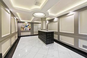 New York apartment for rent - the lobby of a building with a counter and a painting on the wall