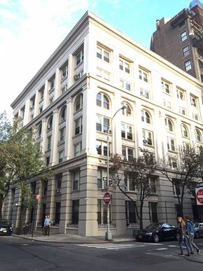 New York apartment for rent - a large white building on the corner of a city street