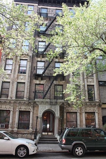 New York apartment for rent - a apartment building with two cars parked in front of it