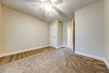 Atlanta apartment for rent - a spacious living room with carpet and a ceiling fan