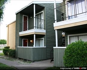 Houston apartment for rent - a green house with a balcony and a sidewalk
