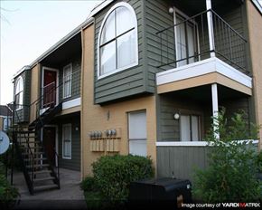 Houston apartment for rent - a green house with a balcony and a staircase