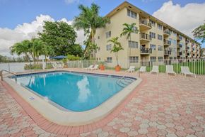 Deerfield Beach apartment for rent - a swimming pool with a building in the background
