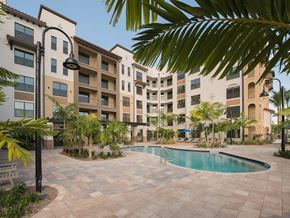 Deerfield Beach apartment for rent - The Crystal Riviyera's backyard, featuring a pool, sun deck, barbecue area, and a view of Sailboat Lake.