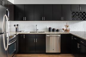 Washington apartment for rent - A kitchen with black cabinets and a stainless steel refrigerator.