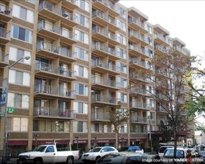 Washington apartment for rent - A large apartment building with balconies and cars parked in front.