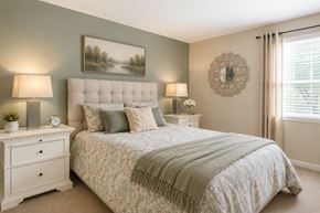 Glen Burnie apartment for rent - A bedroom with a large bed and a painting on the wall.
