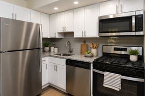 Glen Burnie apartment for rent - A modern kitchen with a stainless steel refrigerator and black oven.