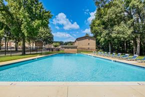 Glen Burnie apartment for rent - a swimming pool with chairs around it and a building in the background