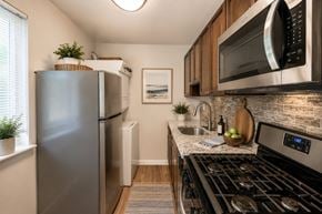 Glen Burnie apartment for rent - A modern kitchen with a stainless steel refrigerator, microwave, and oven.