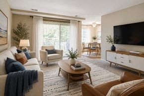 Glen Burnie apartment for rent - A living room with a sofa, armchairs, a coffee table, and a television.