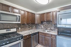 Middle River apartment for rent - a kitchen with stainless steel appliances and wooden cabinets