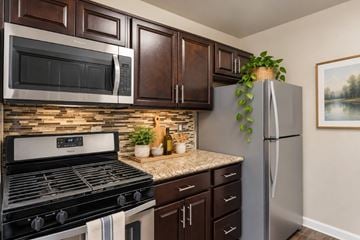 Laurel apartment for rent - A kitchen with a black stove top oven and a silver refrigerator.