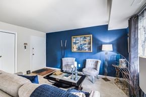 Laurel apartment for rent - A living room with a grey sofa, a coffee table, and a blue wall.