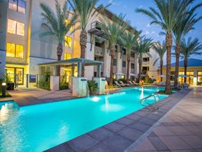 Scottsdale apartment for rent - a swimming pool with palm trees in front of a building