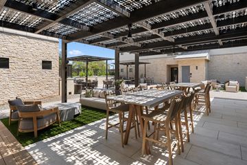Scottsdale apartment for rent - A patio with a table and chairs under a roof with skylights.