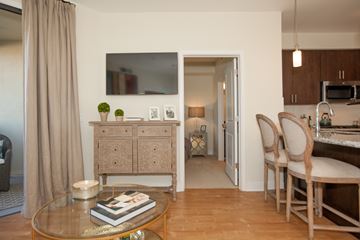 Scottsdale apartment for rent - A living room with a glass table and a television on the wall.