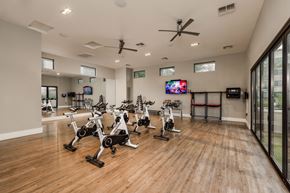 Scottsdale apartment for rent - A gym with a row of stationary bikes and a television mounted on the wall.