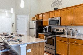 Greer apartment for rent - A kitchen with wooden cabinets and a granite countertop.