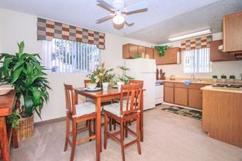 A kitchen and dining room with a table and chairs