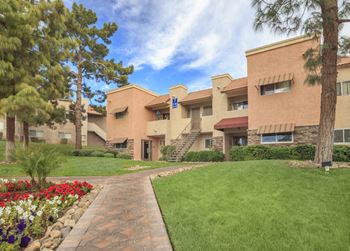 A building with a green lawn and flowers in front of it